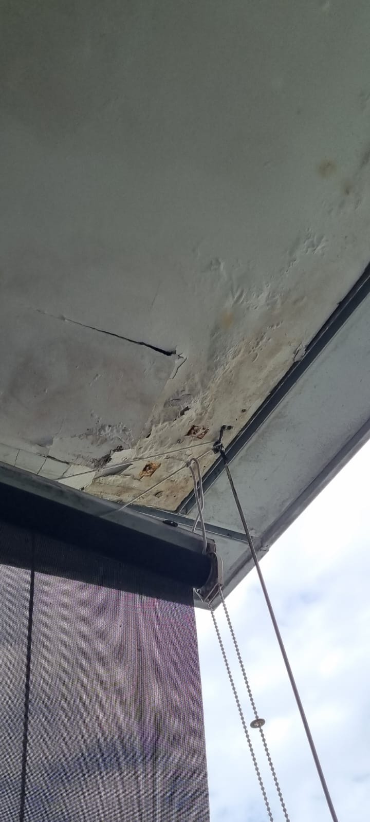 Water-damaged ceiling with peeling plaster and brown leak stains — ceiling leak diagnosis by Shieldguard Singapore