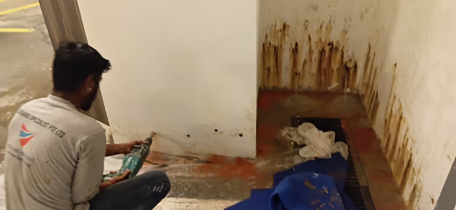 Grey PU liquid waterproofing membrane applied to a horizontal concrete slab with drain outlet in Singapore